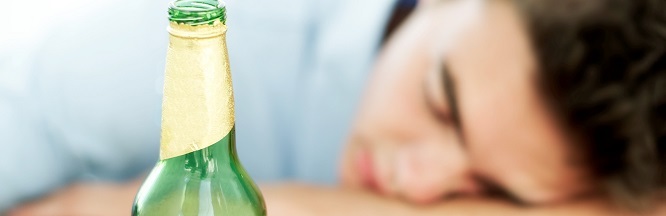 schlafender junger Mann mit Bierflasche
