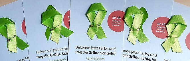 grüne Schleifen auf Postkarten mit Motto "Bekenne jetzt Farbe und trag die Grüne Schleife" liegen nebeneinander