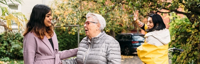 Eine Patin begrüßt eine demenzkranke Frau